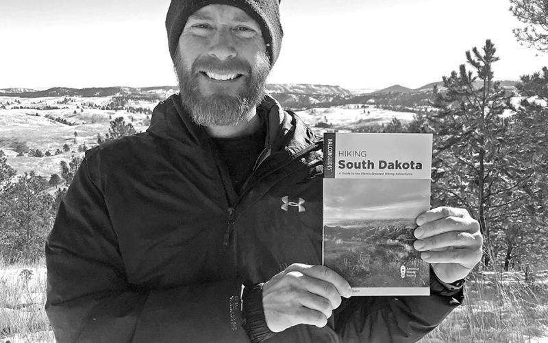 FalconGuides author Marcus Heerdt holds a copy of his new book Hiking South Dakota: A Guide to the State’s Greatest Hiking Adventures while standing at Wind Cave National Park, just one of the many places featured in the guidebook. Submitted photo
