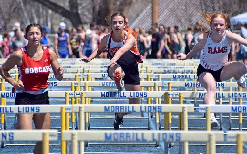 Tavian Urban, center, pushes her limits to set a personal record in the 100-meter hurdles of the Panhandle Conference track meet last week. Photo by Sam Miller