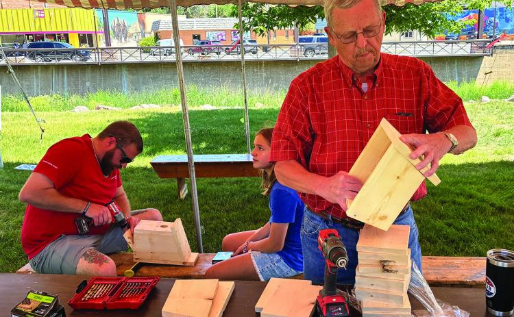 Elks members Jace Thomas and Ted Wick pre-drill holes in the wood and make sure they match up prior to children hammering the nails in. Photo by Charity Maness /Fall River County Herald Star