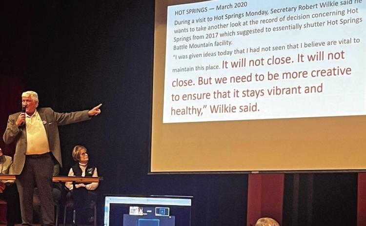 Save the VA co-founder Pat Russell speaks to more than 150 people last Friday night in the Mueller Civic Center as he points to a slide on the screen which quotes former VA Secretary Robert Wilkie who visited the Hot Springs VA in 2020. “It will not close,” is what the then-Secretary said in reference to him rescinding the previous VA Secretary’s record of decision to move forward with a plan to eventually close the Hot Springs VA hospital. Photo by Brett Nachtigall/Fall River County Herald-Star