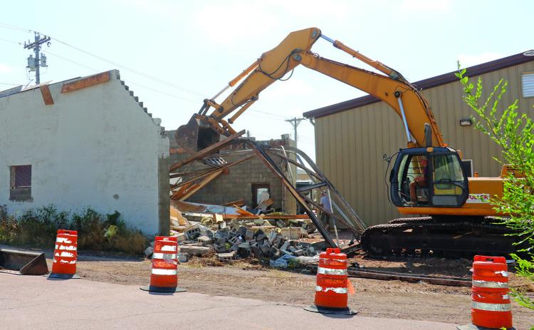 An old storage garage located on property owned by Prairie Hills Transit in downtown Hot Springs was torn down by crews on Monday, Aug. 5. Photo by Brett Nachtigall/Fall River County Herald-Star