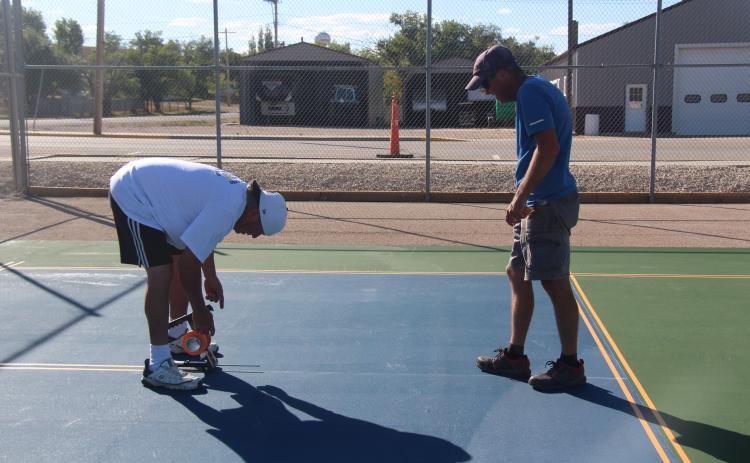 Jesus Calderon and Jason Midgley lay out lines of play on Edgemont’s newly surfaced pickleball court Photo by Linda Baird/Fall River County Herald-Star