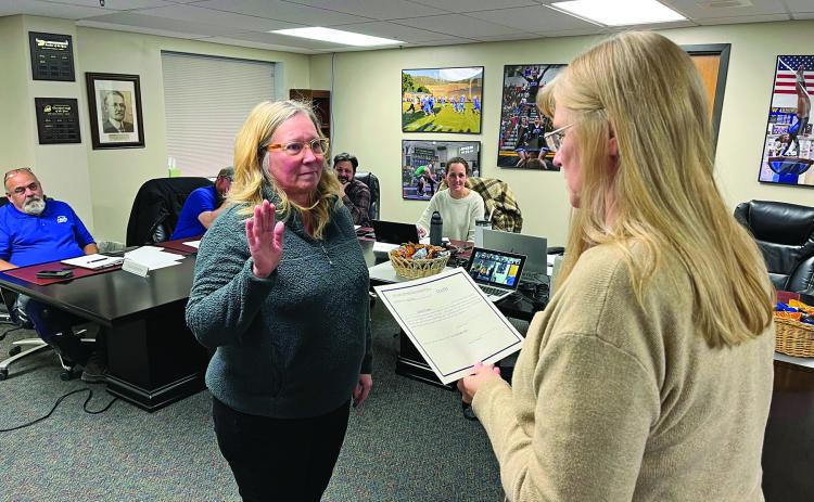 New Hot Springs School Board member Colleen Venner, left, takes the oath of office from Business Manager Wendy Bilbruck during last Monday night’s regular board meeting. Photo by Brett Nachtigall/Fall River County Herald-Star