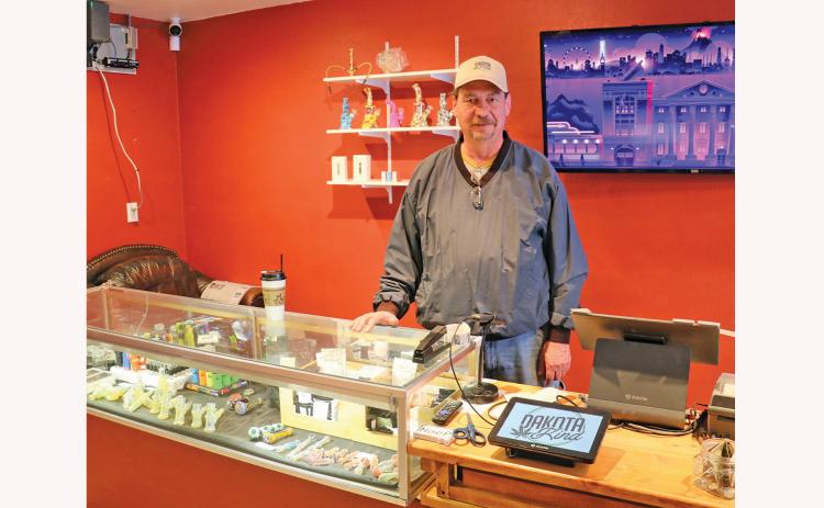 In this photo from April 2023, Dakota Kind owner Forrest Fanning of Caputa poses behind the front counter of his medicinal marijuana dispensary in Hot Springs. Fanning recently asked the city to change its ordinances to allow him to open his own cannabis grow facility, which he said would help him to price his products more competitively compared to Rapid City. Despite getting initial support from the city’s Planning & Zoning Commission and Public Safety Committee, the revisions were shot down by council.