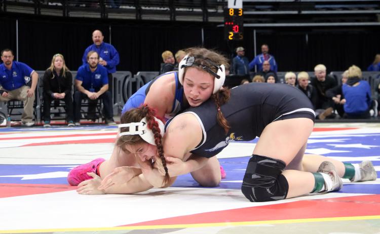 With her coaches looking on from matside, Hot Springs junior Katie Snyder, top, gets control of Kenzie King of Canton in the consolation semifinals, which Snyder won with a 1:47 pin. Photo by Brett Nachtigall/Fall River County Herald-Star