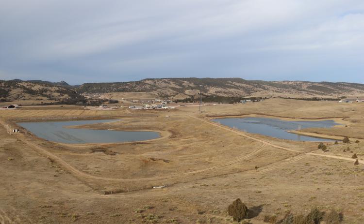 Looking westward from atop a hill, two storage ponds located behind the Coffee Cup Fuel Stop at Maverick Junction sit on property owned by Gary and Sharon Romey. For the past 40 years, these two ponds have accepted effluent from the City of Hot Springs’ wastewater treatment facility where the water is held and eventually used for land application. The higher pond on the right receives the effluent directly via gravity through a 10-inch PVC pipe and then applies the water to a nearby field for flood irrigati