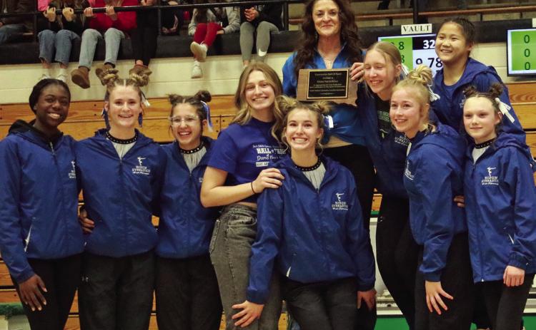 Hot Springs gymnastics coach Dana Nachtigall poses with her team at this past weekend’s State Gymnastic Meet after being presented a plaque inducting her into the S.D. Gymnastics Coaches Association Hall of Fame. Photo by Brett Nachtigall/Fall River County Herald-Star