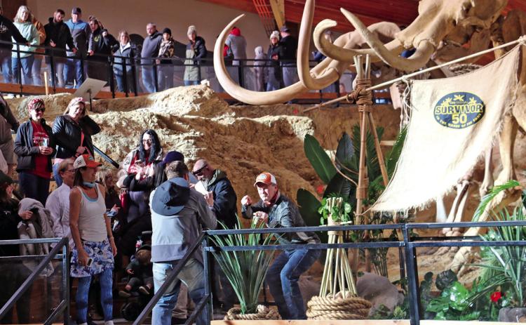 Survivor “super fan” Robert Allison of Pierre poses for a photo while holding the television show’s “idol” placed inside The Mammoth Site this past Saturday morning, as hundreds of other Survivor fans wait in line for their turn to do the same. The event was part of a 50-state promotional tour celebrating the global reality-competition television show’s 50th season, debuting on CBS/ Paramount+ later this month. Photo by Brett Nachtigall/Fall River County Herald-Star