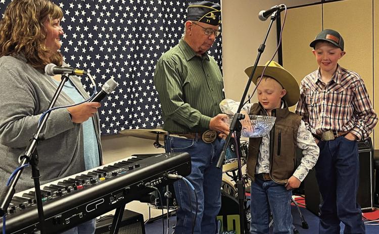Helping Jim Woehl, young Weston Wright reaches into a bowl and draws out the name of Don Olstad as the winner of a pistol donated by Woehl during a fundraiser of the RJ Wright Family this past weekend. Also pictured is Tara Walz, far left, and Morgan Wright, far right. Photo by Brett Nachtigall/Fall River County Herald-Star