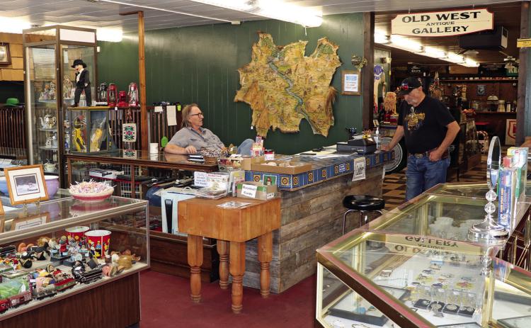 John Stanley sits behind the front counter of his business while visiting with a customer inside KSK Antiques, located at 138 S. Chicago Street in downtown Hot Springs. Photo by Brett Nachtigall/Fall River County Herald-Star