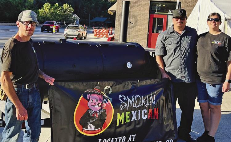 Smokehouse Sports Bar and Grill competition crew Galen Ballasy, Chef Daniel Valdivia and Mercedes Uehling stand with their Prairie Wind Casino BBQ Cook Off 1st place prize ‘Buurnice’ a 250 gallon reverse flow smoker. Photo by Charity Maness/Fall River County Herald Star