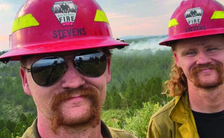Newly elected Hot Springs Volunteer Fire Department Chief Riley Stevens (left) at work on a fire with his brother Seth. Courtesy photo