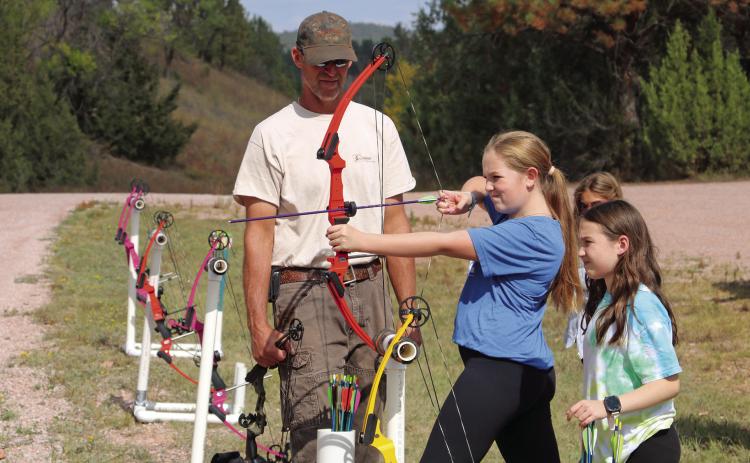 GFP’s Loren Vande Stroet works with Hot Springs 5th grade students Anika Kindred and Nikki Cummings during an archery exercise as part of the recent JAKES event at Cold Brook Photos by Brett Nachtigall/Fall River County Herald-Star