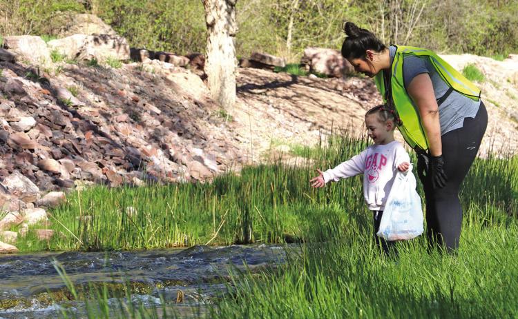 Lauren Cusano of Hot Springs stands next to her daughter Angela, age 4, as their family helps clean up around Brookside Park during this past weekend’s Great American Cleanup. Also helping nearby were Lauren’s husband Eric and their other daughter Isabella. Photo by Brett Nachtigall/Fall River County Herald-Star