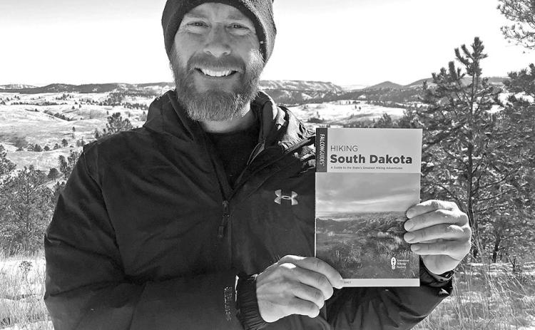 FalconGuides author Marcus Heerdt holds a copy of his new book Hiking South Dakota: A Guide to the State’s Greatest Hiking Adventures while standing at Wind Cave National Park, just one of the many places featured in the guidebook. Submitted photo