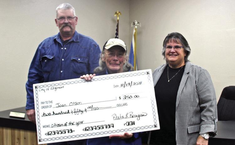 Councilman Brent White (left) and Mayor Rheta Reagan (right) present a check for $250 to Joan Olson at the Nov. 19 Edgemont City Council meeting when she was surprised with the honor of being named Citizen of the Year. Photo by Linda Baird/FRC Herald Star