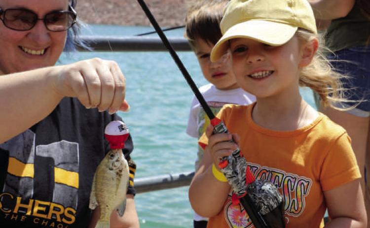 Elizabeth Graf, 6, caught the first fish of the day held by Melissa Fleming. Photos by Charity Maness/Fall River County Herald Star