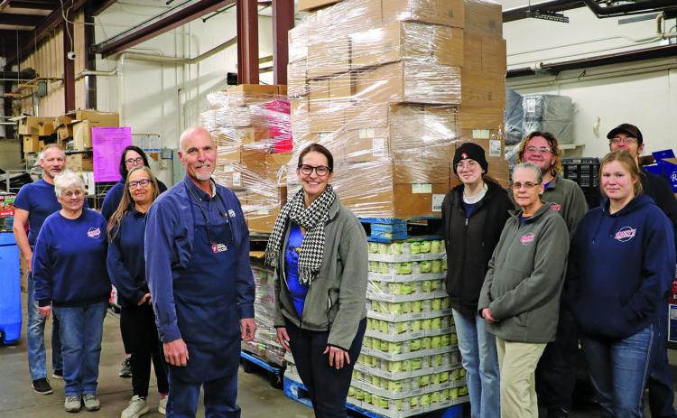 With the equivalent of 432 bags of groceries piled high behind them, the staff of Sonny’s Super Foods in Hot Springs poses for a photo with Sonny’s Manager Dan Grapentine, left, and Hot Springs Food Pantry Manager Kay Birkholt. Thanks to a joint effort by several members of the community, the large stack of food was purchased and delivered to the food pantry last Friday, Jan. 17. Photo by Brett Nachtigall/Fall River County Herald-Star