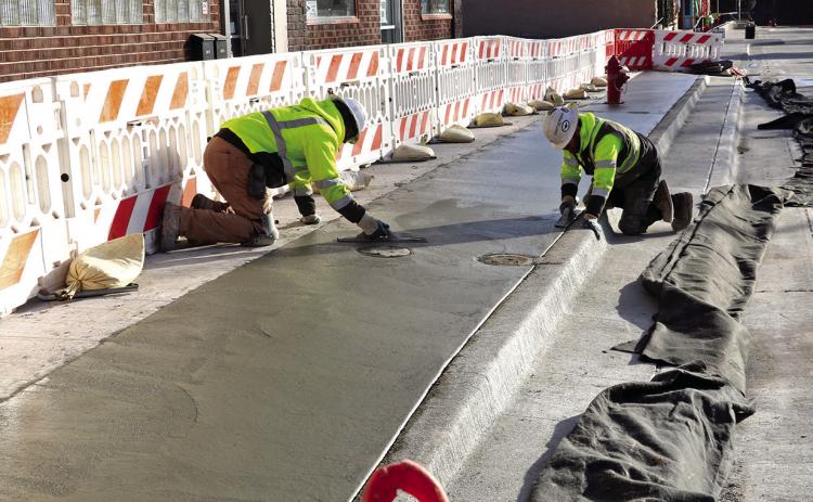 Workers with Complete Concrete last week began replacing the sloped sidewalk boulevard with a new ‘double curb’ design to help with the transitionally safety from the storefronts to the lower roadway. Photo by Brett Nachtigall/Fall River County Herald-Star