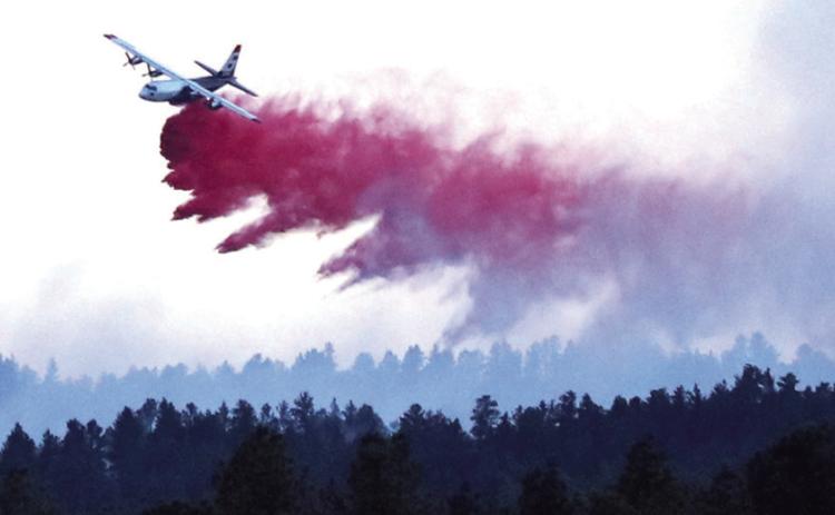 An airtanker drops a load of fire retardant slurry onto the Green Acres Fire, located three miles southwest of town. The fire started on Saturday, March 1, and was mostly contained by Monday, March 3. Photo by Brett Nachtigall/Fall River County Herald-Star