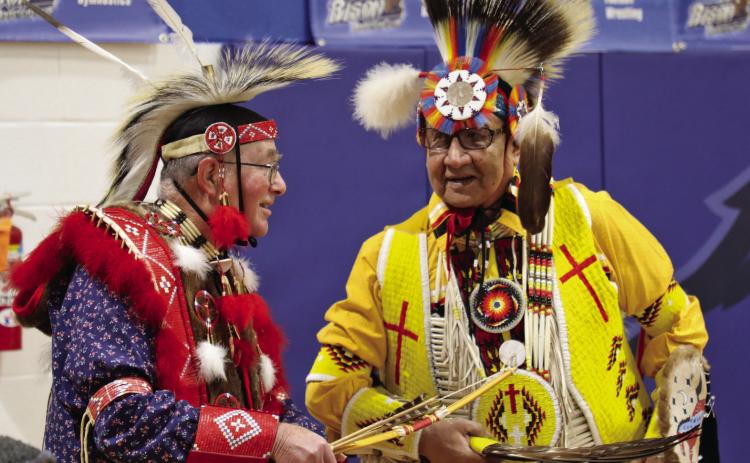 Gerald Collogan of Hot Springs, left, a self-proclaimed hobbyist, chats with Tommy Ghost Dog before the New Years Powwow at Case Auditorium on Wednesday, Jan. 1. Collogan created his entire ensemble by hand – beading, sewing, all of it. Photo by Charity Maness/Fall River County Herald Star